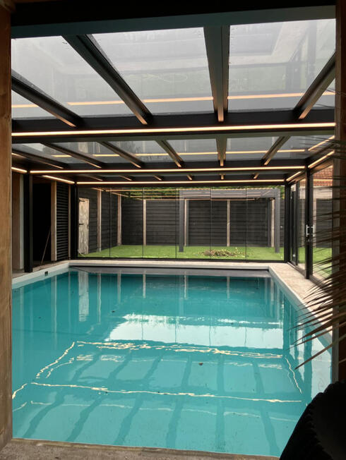 Glasüberdachung mit Schiebeelementen Überdachter Poolbereich mit Aluminiumkonstruktion und großflächigen Glasschiebeelementen